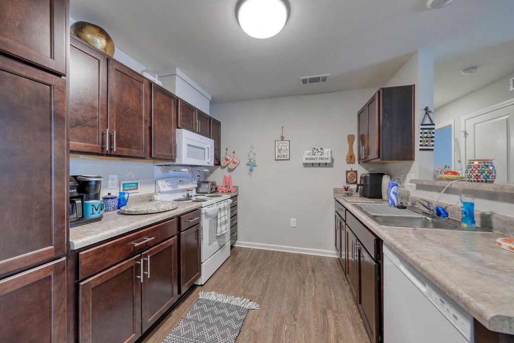 a kitchen with dark wood cabinets and white appliances