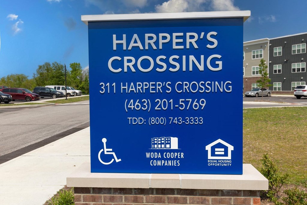 a sign for harpers crossing on the side of a road