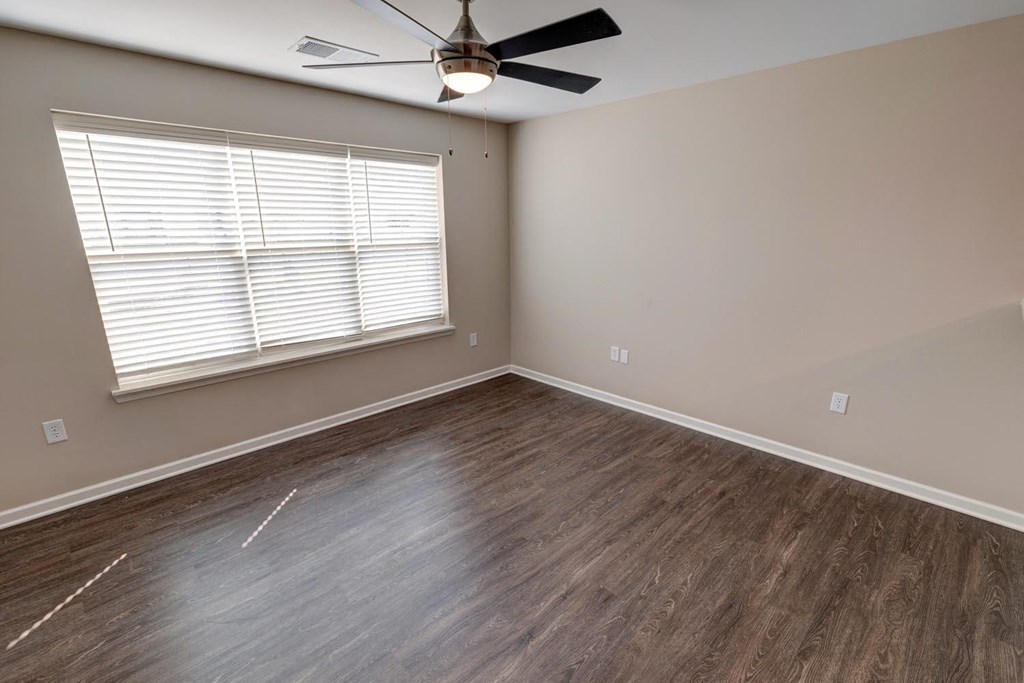 a bedroom with hardwood floors and a ceiling fan