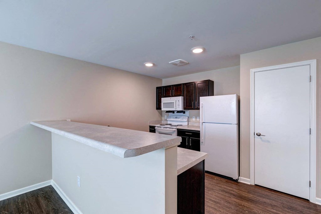 a kitchen with a white refrigerator freezer next to a stove top oven