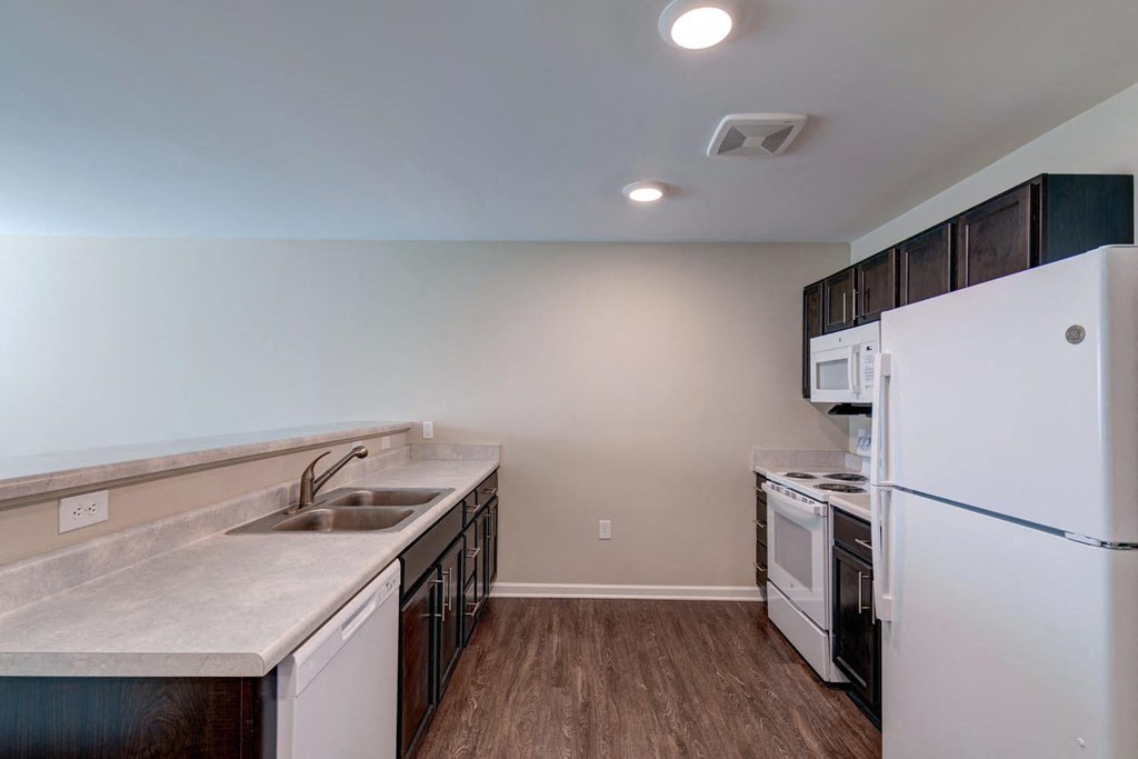 a kitchen with white appliances and wood flooring