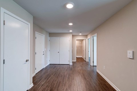a renovated living room with wood floors and white closets