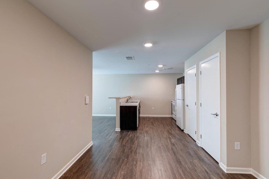 a kitchen and living room with hardwood floors and beige walls