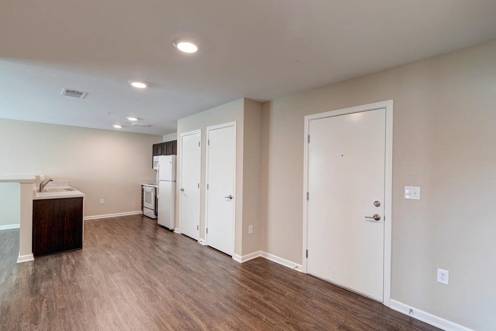a bedroom with a medium hardwood floor and a kitchenette