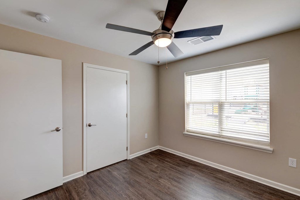 a bedroom with hardwood floors and a ceiling fan