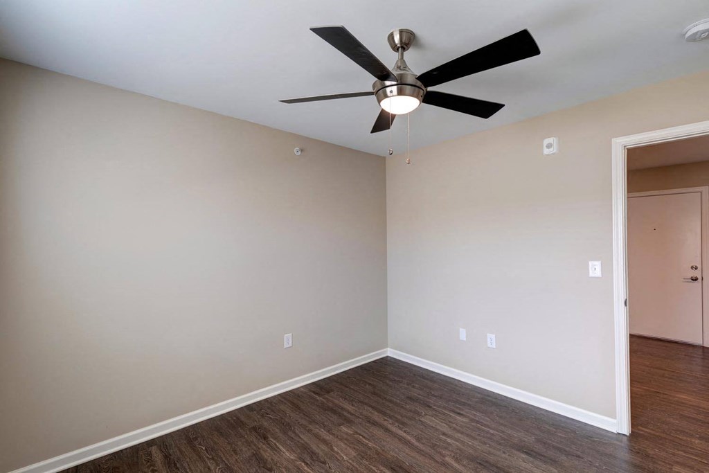 a bedroom with a ceiling fan and hardwood floors