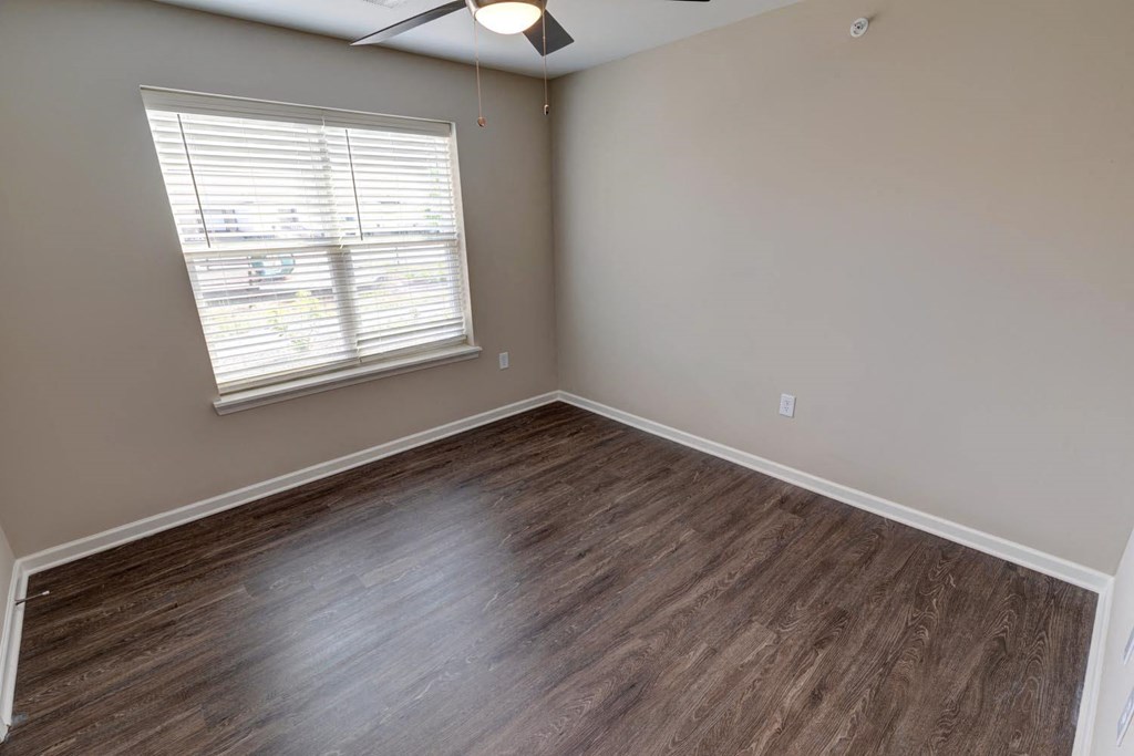 an empty room with a window and a ceiling fan