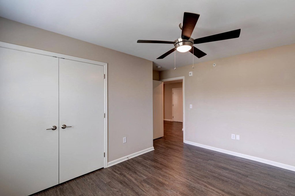 a bedroom with a ceiling fan and closet