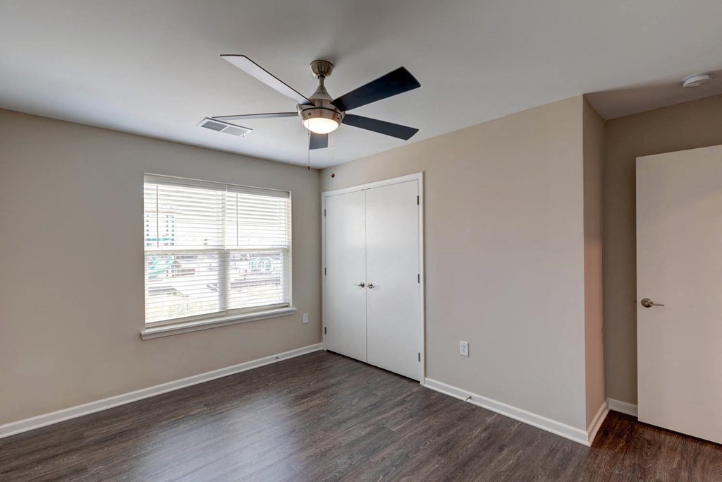 a bedroom with hardwood floors and a ceiling fan