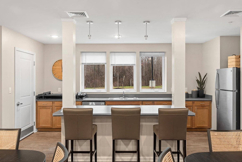A kitchen with brown chairs and a large island.