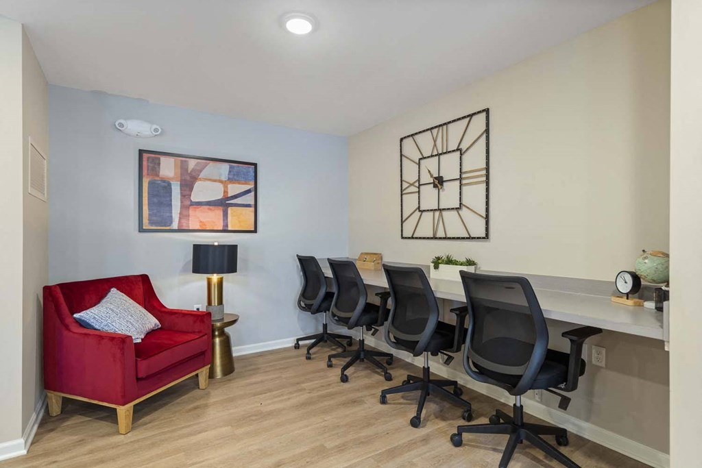 a conference room with a desk and chair and a red couch