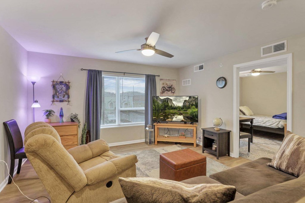 a living room with a couch and a chair and a tv