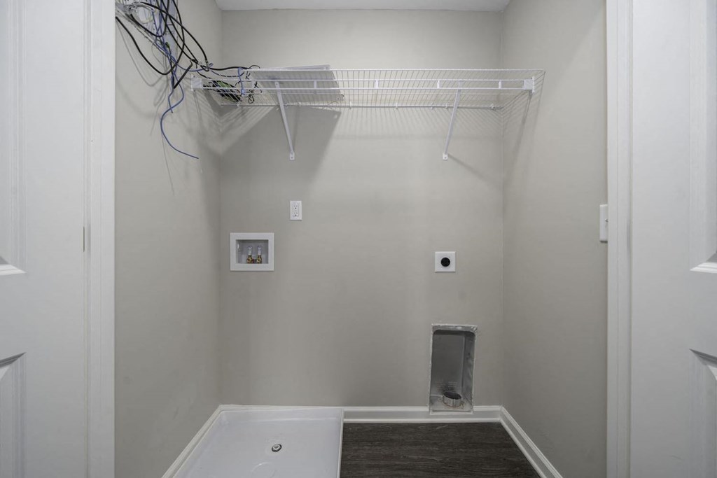 a walk in closet in a bathroom with a tub and a rack on the wall