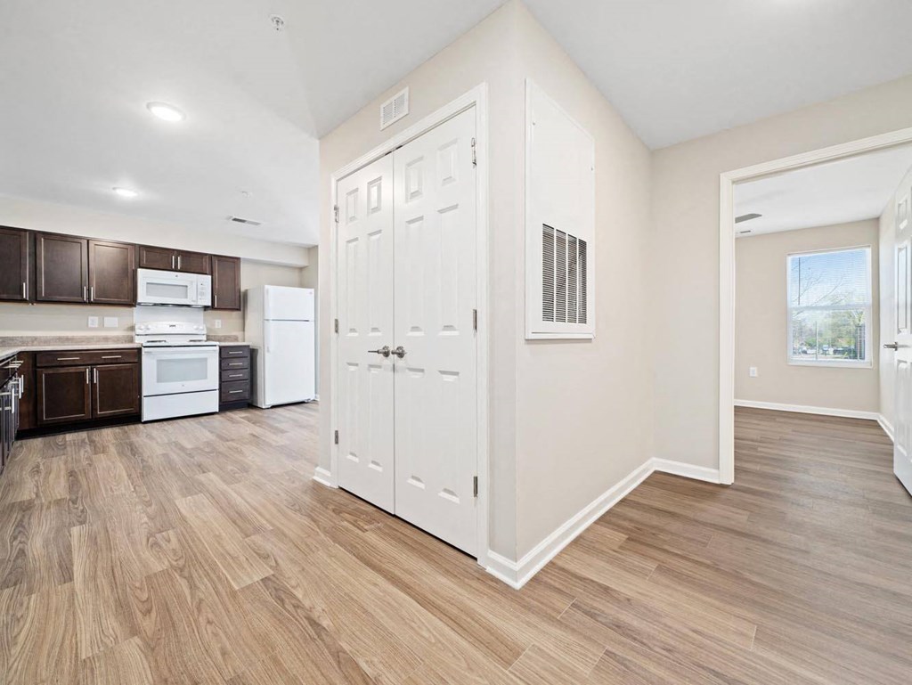 a renovated kitchen with white cabinets and a wood floor