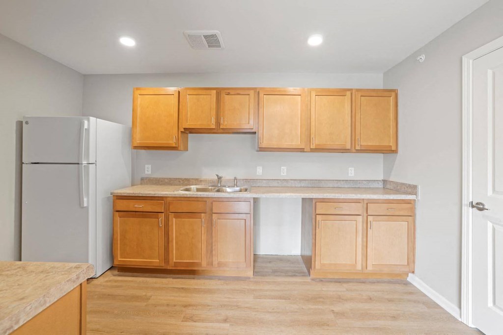a kitchen with wooden cabinets and a refrigerator