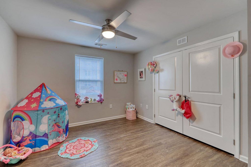 a playroom with a play tent and a ceiling fan