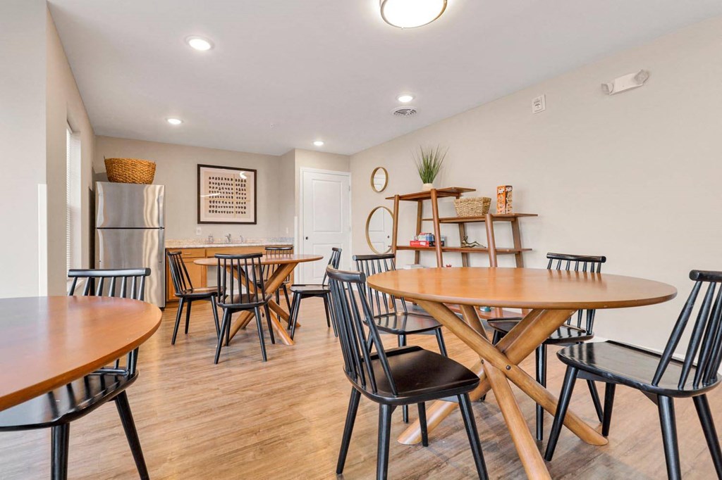 a dining room with tables and chairs and a refrigerator