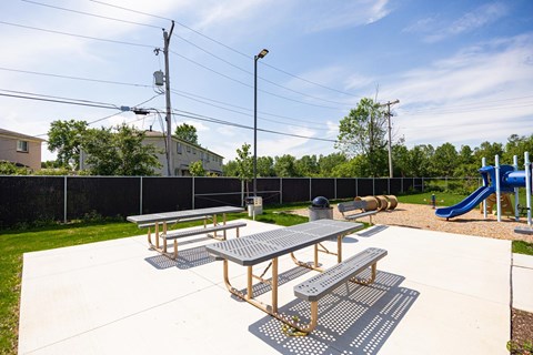 A picnic table is in the middle of a playground.