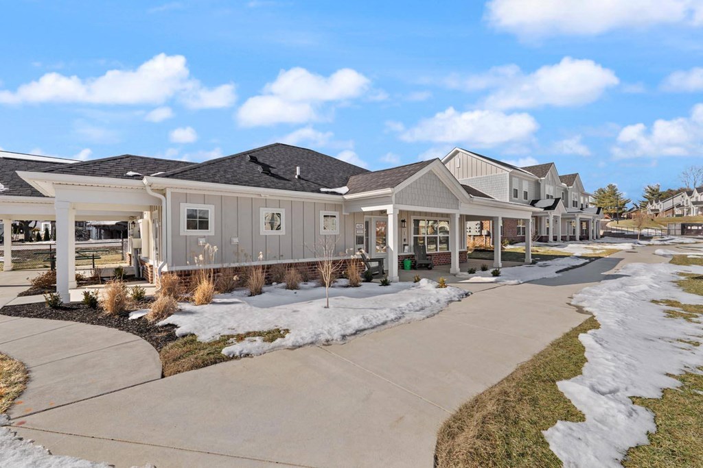 A row of houses with a sidewalk in front.