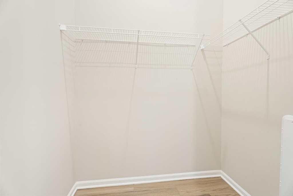 A white wall with a white shelf on it.