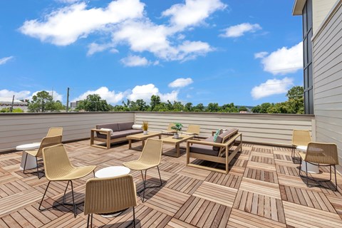 A wooden deck with chairs and a table.