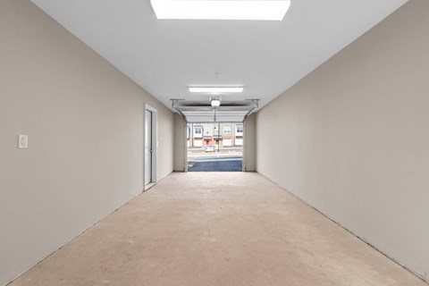 A long, empty hallway with a skylight above and doors on both sides.
