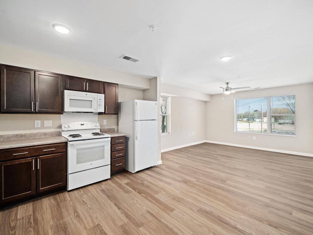 a kitchen with white appliances and wooden floors