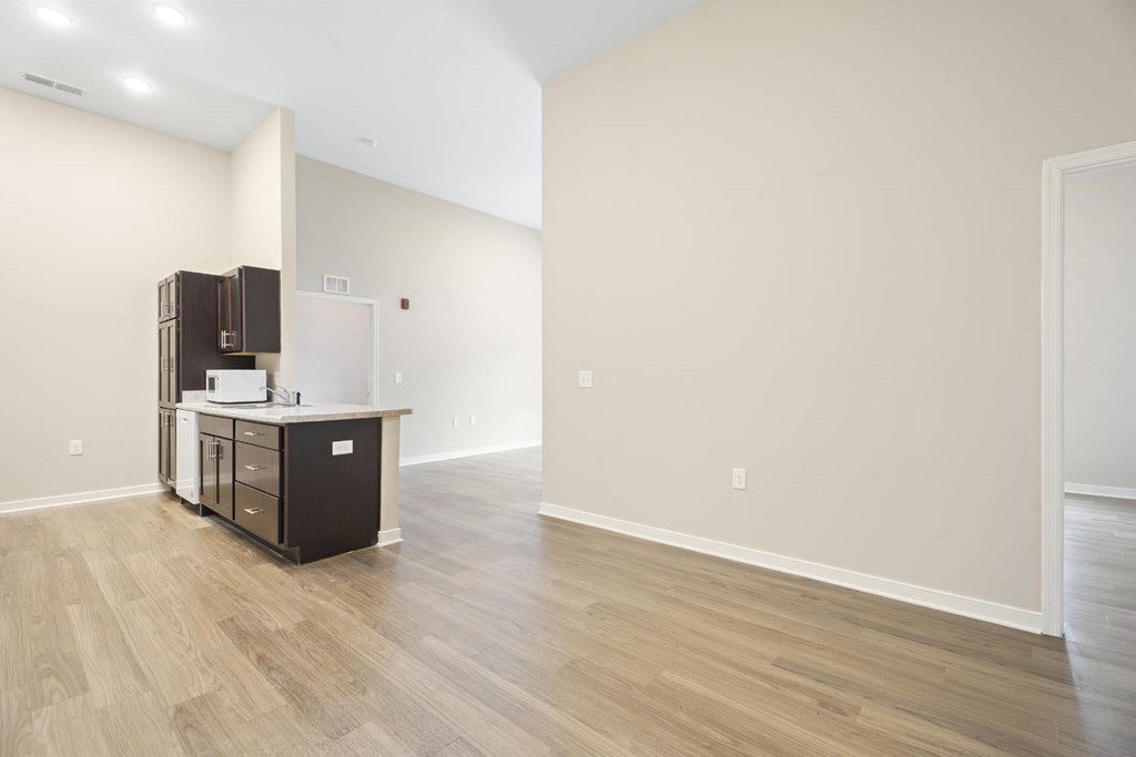A kitchen area with a refrigerator, cabinets, and a countertop.