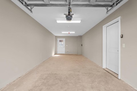 A long, empty hallway with a white door at the end.