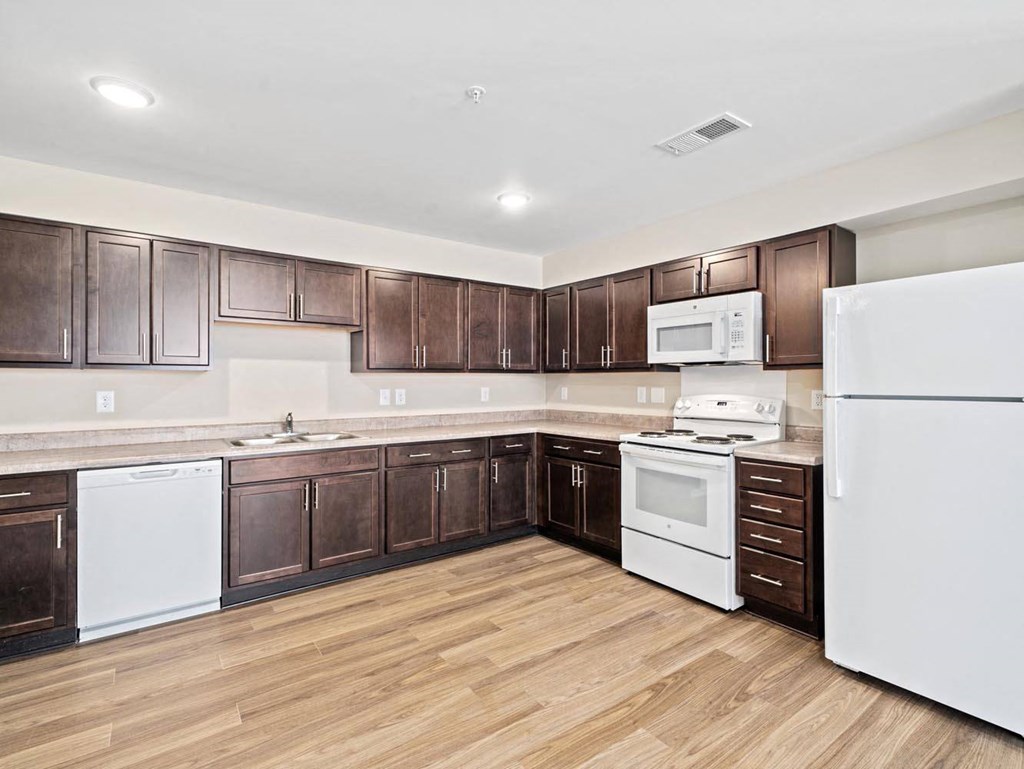 a kitchen with white appliances and brown cabinets