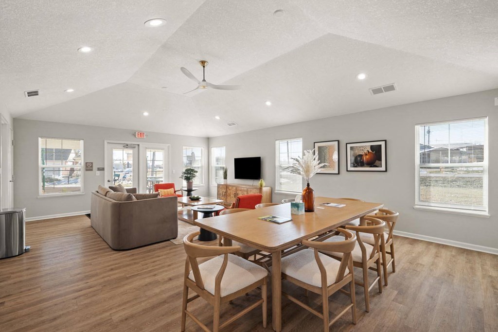 A spacious dining room with a wooden table and chairs.