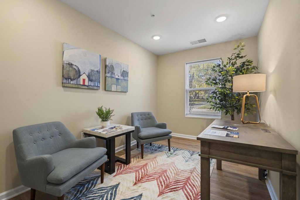 a living room with chairs and a table and a window