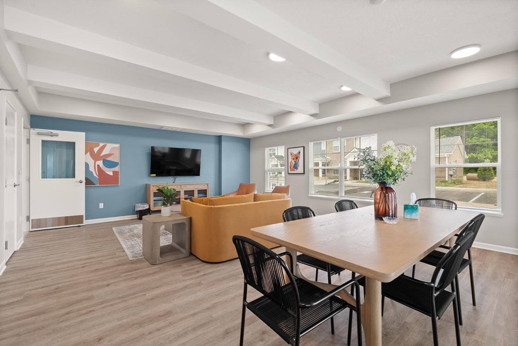 A dining room with a wooden table and chairs.