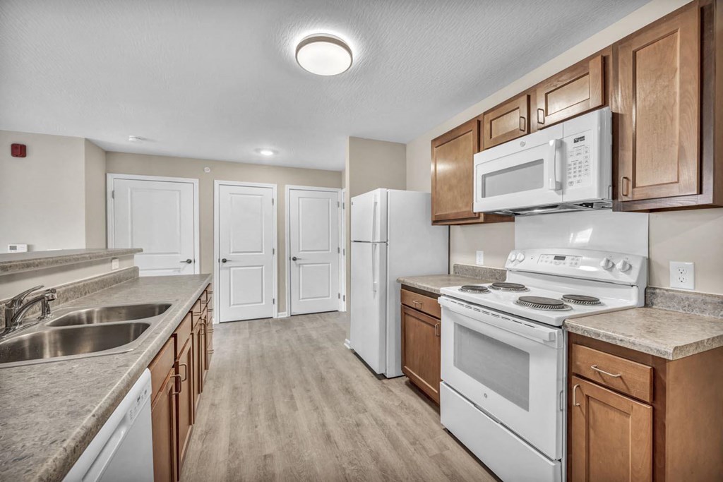a kitchen with white appliances and wooden cabinets