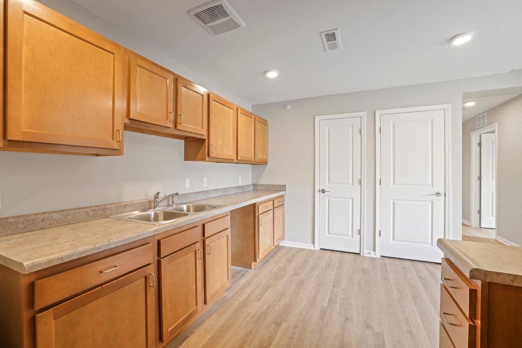 a kitchen with wooden cabinets and a sink and a door