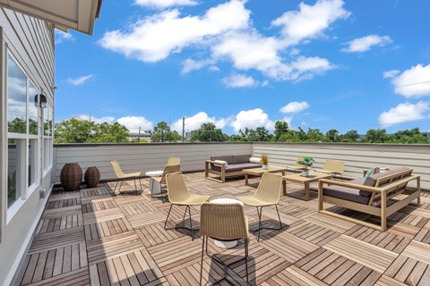 A wooden deck with chairs and a table.