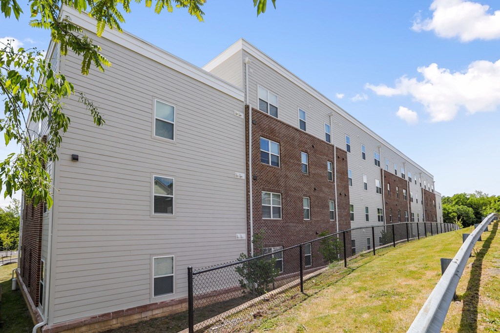 a brick and siding building with a chain link fence in front of it