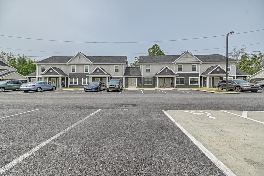 a parking lot with several houses in the background