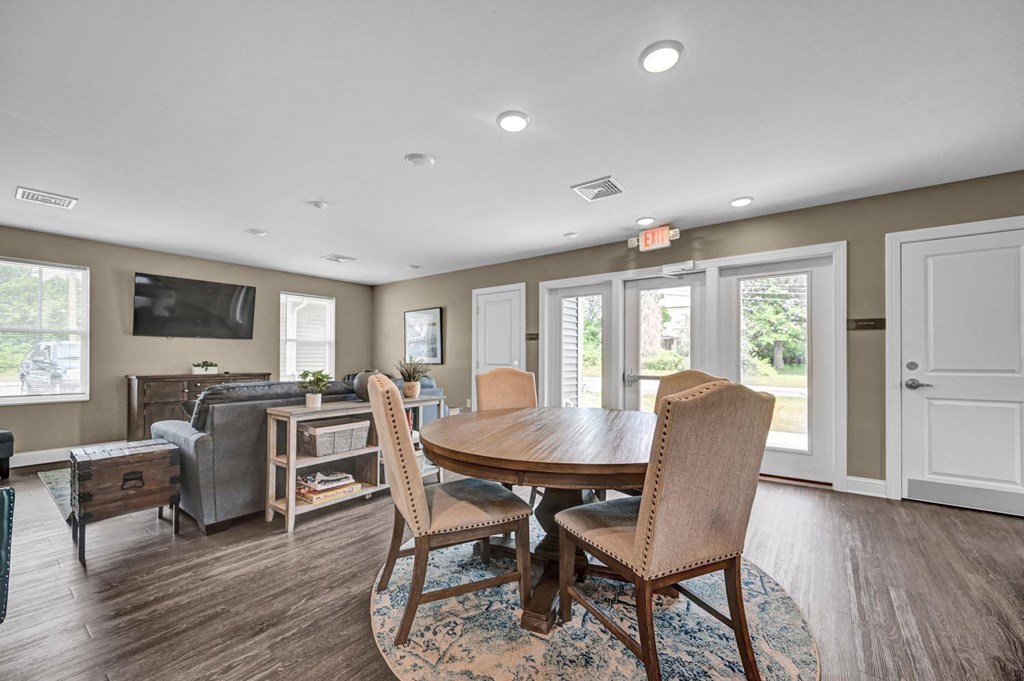 a table with chairs in a room with a couch and a tv