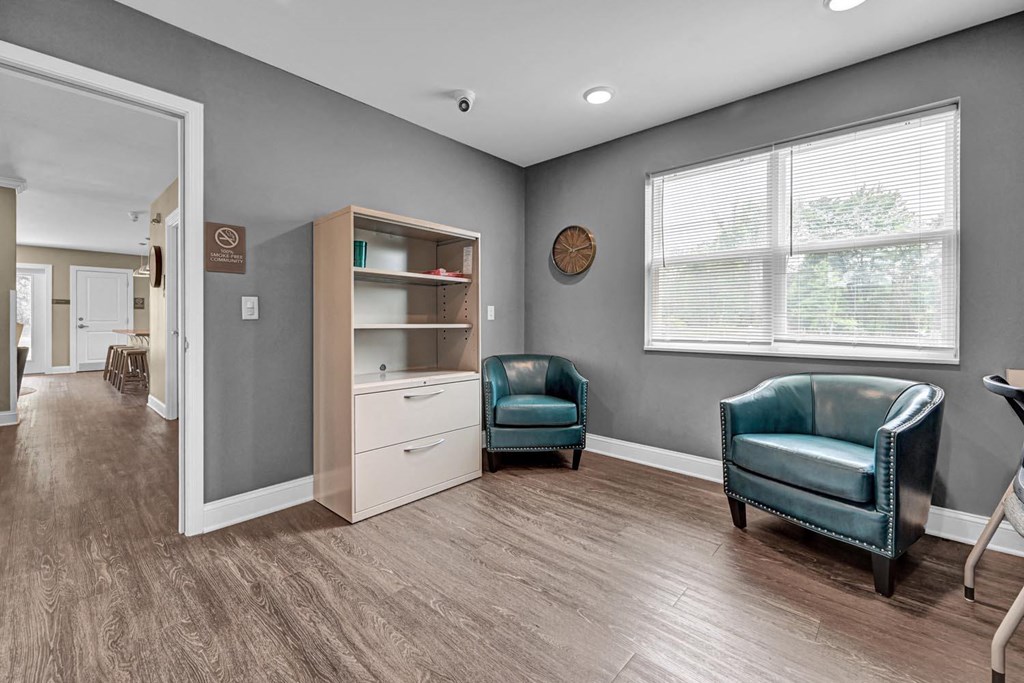 a therapy room with two chairs and a bookcase