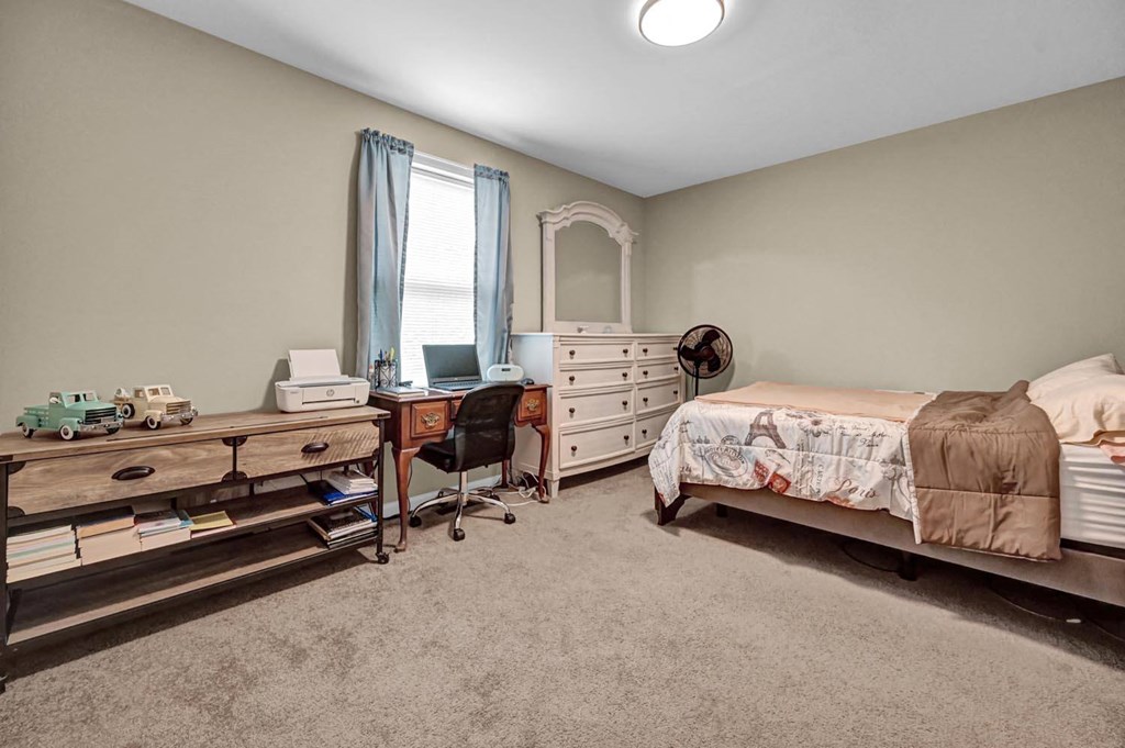 a bedroom with a bed and a desk