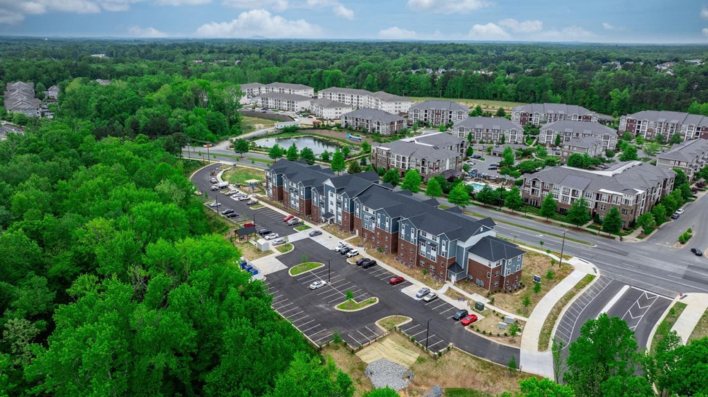 an aerial view of an apartment complex and parking lot