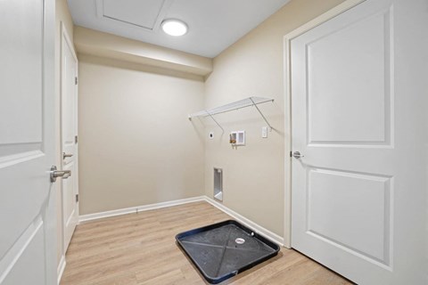 a white room with a door and a black rug on the floor