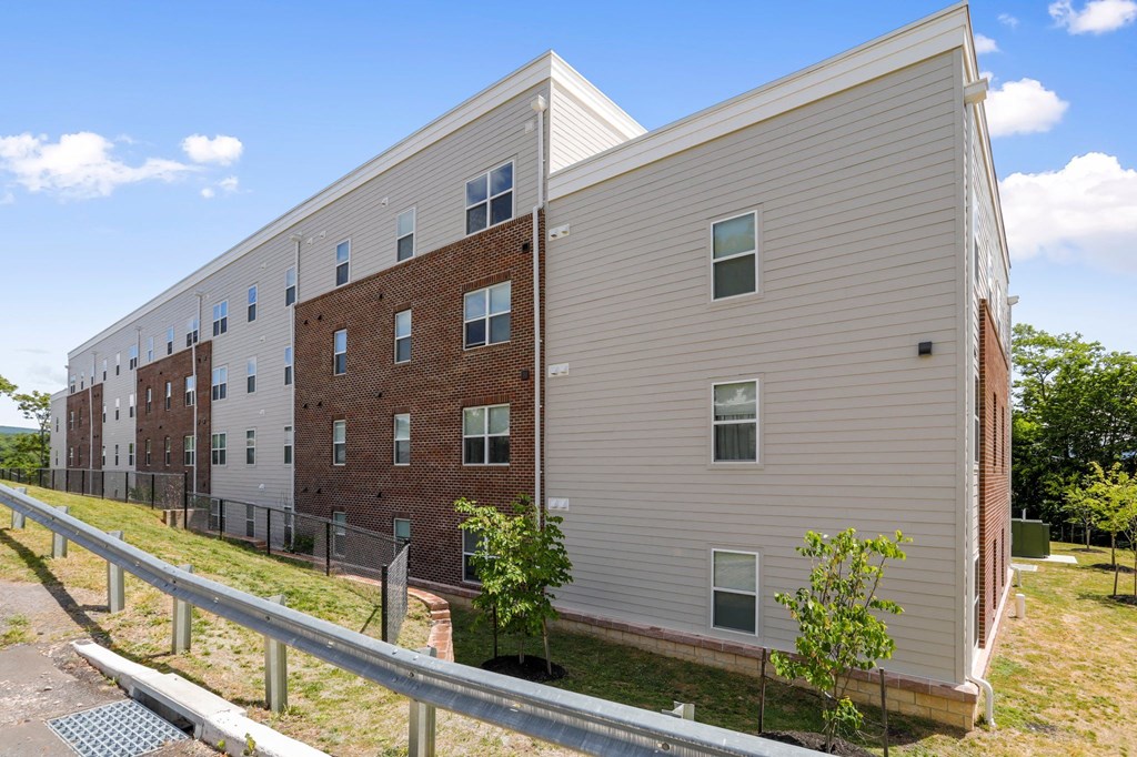 a brick and siding building with trees in front of it
