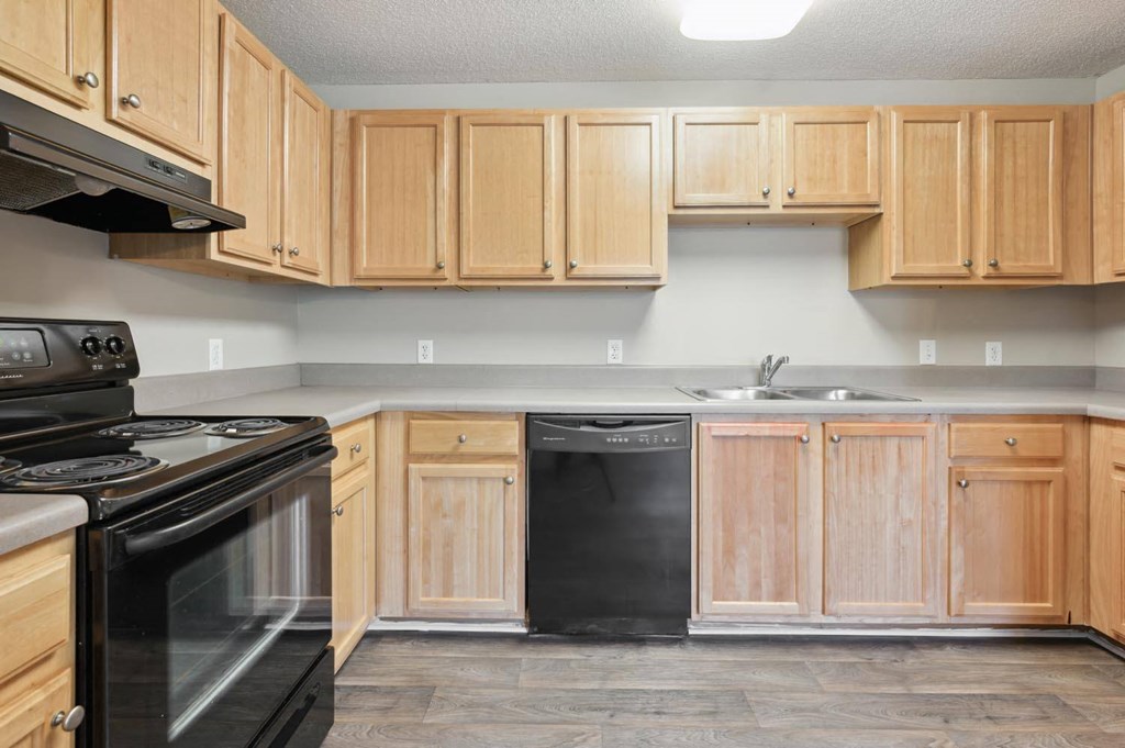 a kitchen with wooden cabinets and black appliances