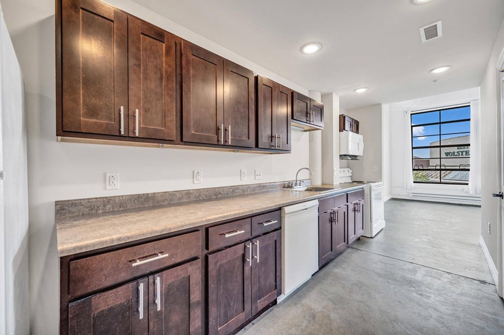 a kitchen with wooden cabinets and a white dishwasher
