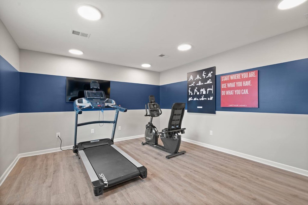 A room with a treadmill and a stationary bike.