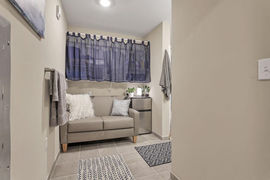 a living room with a couch and a window with a curtain