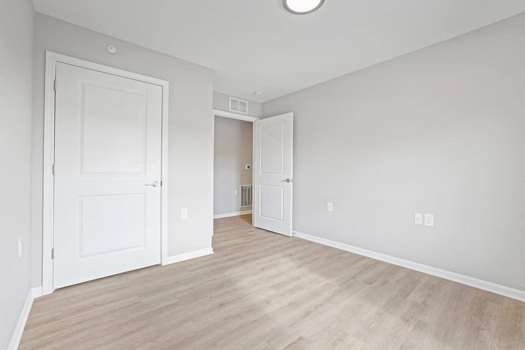 an empty living room with white walls and wood floors