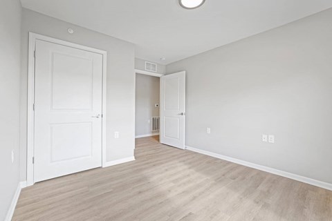 an empty living room with white walls and wood floors